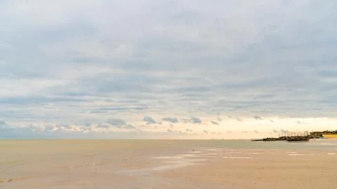 Dramatic clouds float on the coast of the blue sea Stock Photos
