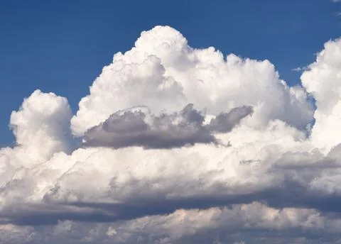 Dramatic clouds float on the coast of the blue sea Stock Photos