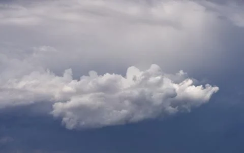 Dramatic clouds float on the coast of the blue sea Stock Photos