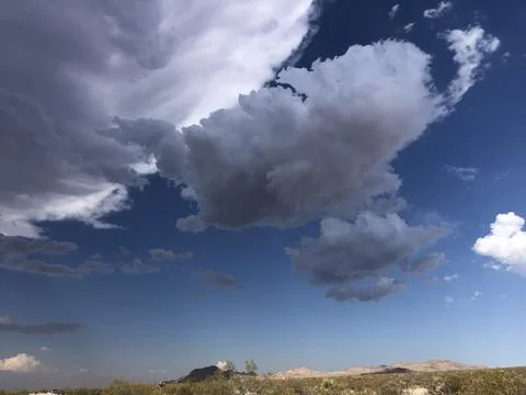 Dramatic Clouds Float Over a Desert Landscape During Golden Hour Stock Photos