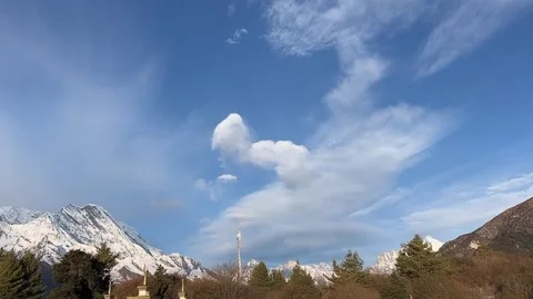 Dramatic Clouds Flowing Over Snow Mountains with Blue Sky in Tibet Video stock 330142189