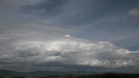 Dramatic clouds form over rolling hills and distant city. Stock Footage 336328261
