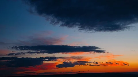 Dramatic clouds formatting storm in bright colors during sunset. Red, orange Stock Footage 105157162