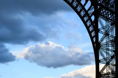 Dramatic clouds frame the Eiffel Tower's iconic steel arch Stock Photos