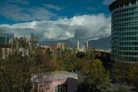 Dramatic clouds frame Tirana's Mosque and mountains Stock Photos