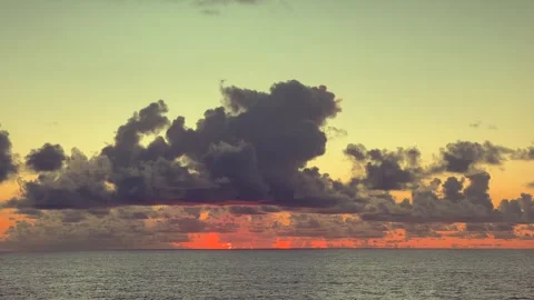 Dramatic clouds gather over the ocean at sunset, painting the sky with warm.. Stock Footage 338282797