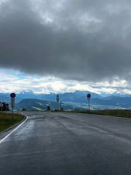 Dramatic Clouds Hang Low Over Alpine Road Stock Photos