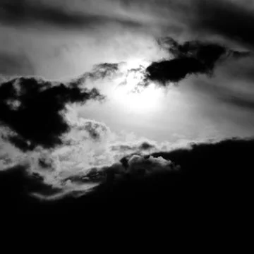 Dramatic clouds in a hazy sky, backlit by the sun Stock Photos