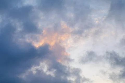 Dramatic clouds illuminated by sunset hues in the evening sky above a tranq.. Stock Photos