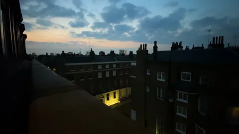 Dramatic clouds move at evening over the rooftops and skyline of London Stock Footage 164576976