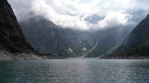 Dramatic clouds moving over alpine lake and mountains Stock Footage 318278190