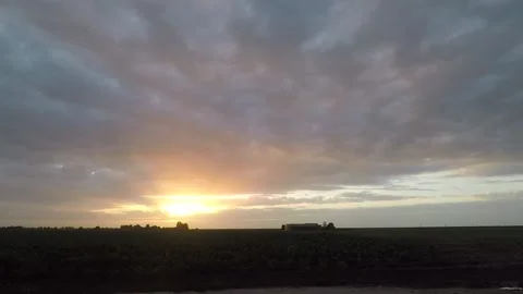 Dramatic clouds moving over farmland at sunset Stock Footage 134419263