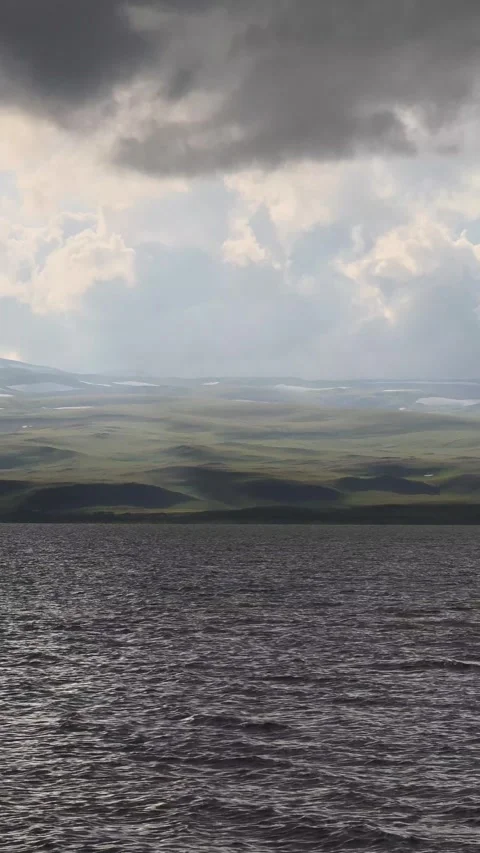 Dramatic clouds moving over a lake and hills Stock-Footage 311336116