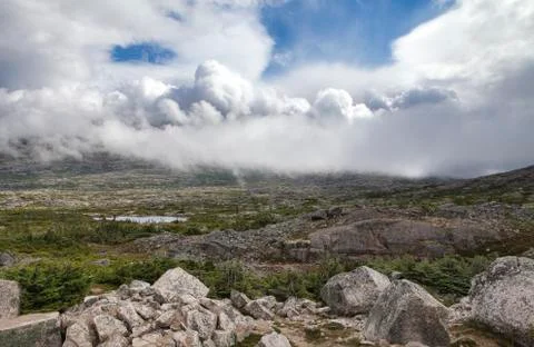 Dramatic clouds moving over mountains near White Pass Stock Photos