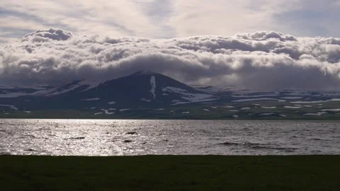 Dramatic clouds moving over a snow-capped mountain and lake 库存影片 339157033
