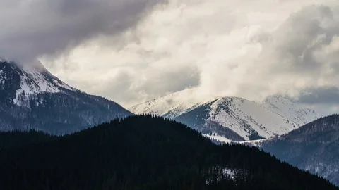 Dramatic clouds moving over snowy alpine mountains in cold winter Time lapse Stock Footage 105301978
