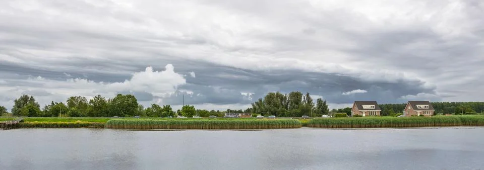 Dramatic clouds near a river Stock Photos