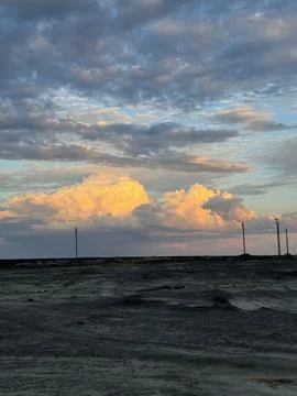 Dramatic clouds over barren terrain at sunset Stock Photos