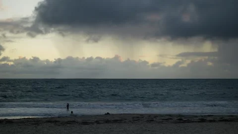 Dramatic clouds over a beach in Perth Australia and woman with her dog 6K Stock Footage 311877370