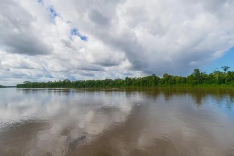 Dramatic Clouds Over Brown Water River In Suriname Stock Photos