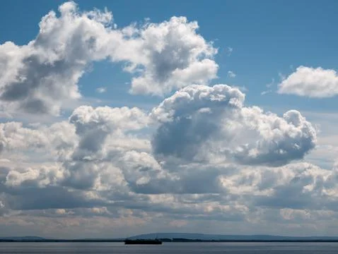 Dramatic clouds over calm sea with cargo ship Foto stock