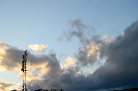 Dramatic clouds over communication tower and urban rooftops Foto stock