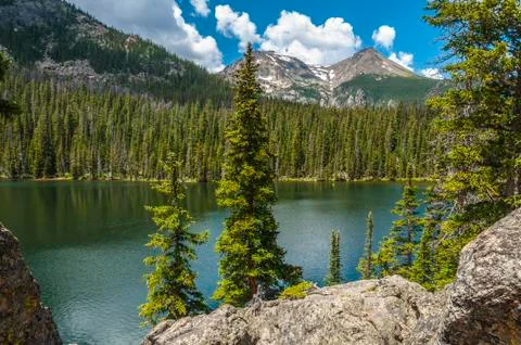 Dramatic clouds over fern lake with stones peak mountain in colorado rockies Stock Photos