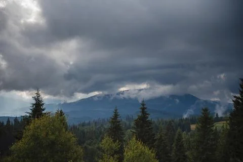 Dramatic Clouds Over Forested Mountain Landscape Stock Photos