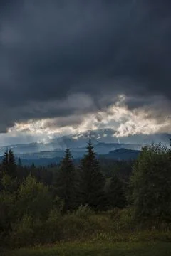Dramatic Clouds Over Forested Mountains Stock Photos