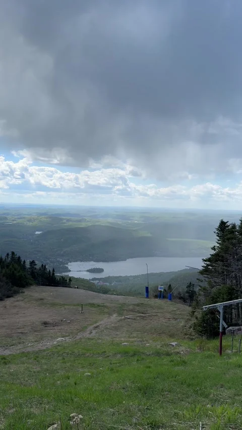 Dramatic Clouds Over Mountain Slope and Distant Lake Stock Footage 346503086