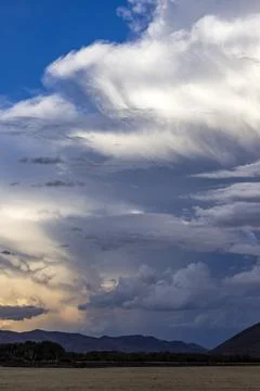 Dramatic clouds over mountains and field Foto stock