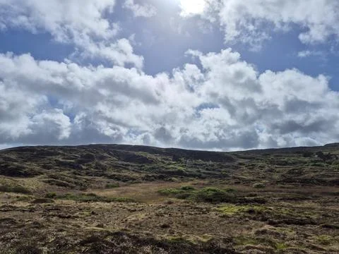 Dramatic clouds over rugged hillside landscape 스톡 사진