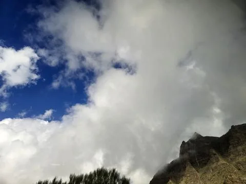 Dramatic clouds over rugged mountain peak Stock Photos