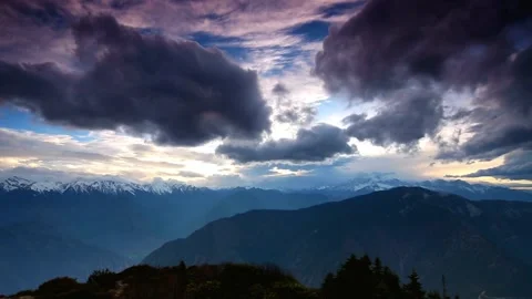 Dramatic clouds over snow capped mountains in a vast and scenic landscape 動画素材 311818438