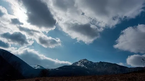 Dramatic clouds over the tops of snow-capped mountains and hills Video stock 150598462