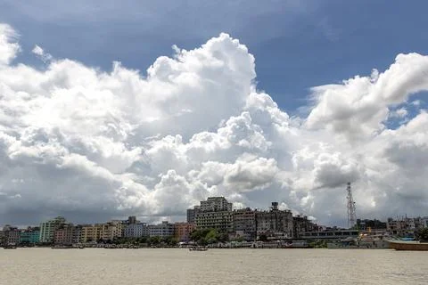 Dramatic Clouds Over Urban Riverside Cityscape with Boats and Afternoon Light Stock Photos