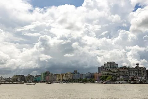 Dramatic Clouds Over Urban Riverside Cityscape with Boats and Afternoon Light Stock Photos