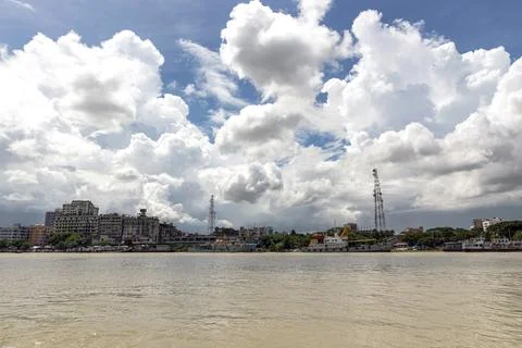 Dramatic Clouds Over Urban Riverside Cityscape with Boats and Afternoon Light Stock Photos