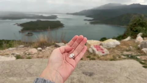 Dramatic clouds over water with oval diamond engagement ring landscape Stock Footage 319441214