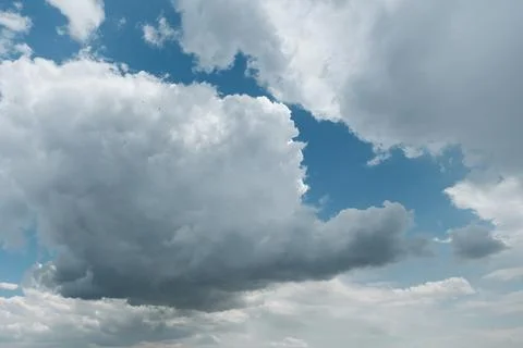 Dramatic clouds with patches of blue sky and flying small swallows Stock Photos
