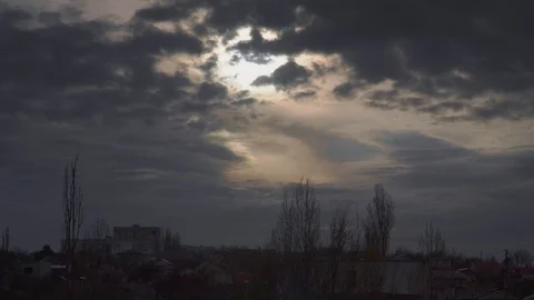 Dramatic clouds quickly fly in the sky behind the trees and houses Stock Footage 107071064