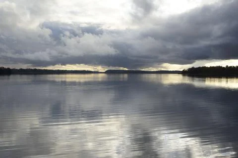 Dramatic clouds reflected in the water of a lake Stock Photos