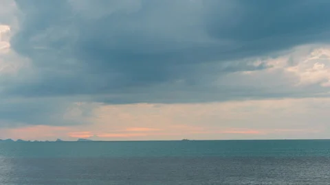 Dramatic Clouds Shift Rapidly Above the Calm Tropical Sea as the Sun Sets and Stock Footage 312695808