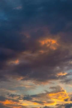 Dramatic clouds at sunrise. Partly cloudy sky vertical background photo Stock Photos
