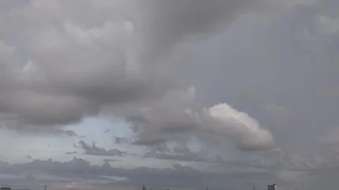 Dramatic clouds swirl above a tranquil landscape 動画素材 310039671