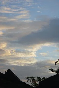 Dramatic clouds with warm sunset light and blue sky background 写真素材