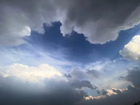 Dramatic Cloudscape with Blue Sky Opening and Sunlit Storm Clouds Background Stock Photos