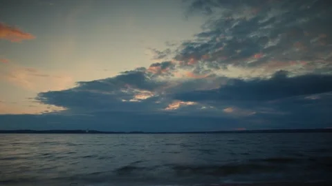 Dramatic cloudscape looming over the lake during sunset. Time lapse video Stock Footage 286122216