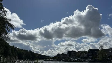 Dramatic cloudscape over Amsterdam canal neighborhood with blue sky, cumulus Stock-Fotos