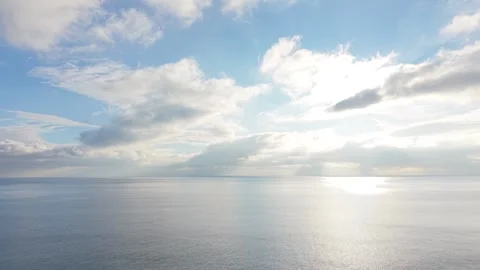 Dramatic cloudscape over calm sea with mirror reflections and horizon Stock Footage 327840313